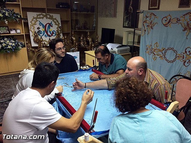 Los primeros miembros del taller de bordado atendiendo algunas explicaciones para proceder con el bordado de la bandera.